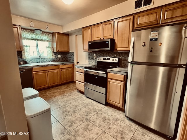 kitchen featuring light tile patterned floors, tasteful backsplash, visible vents, appliances with stainless steel finishes, and a sink