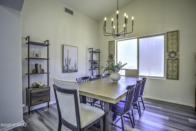 dining area with wood finished floors, visible vents, high vaulted ceiling, and a notable chandelier
