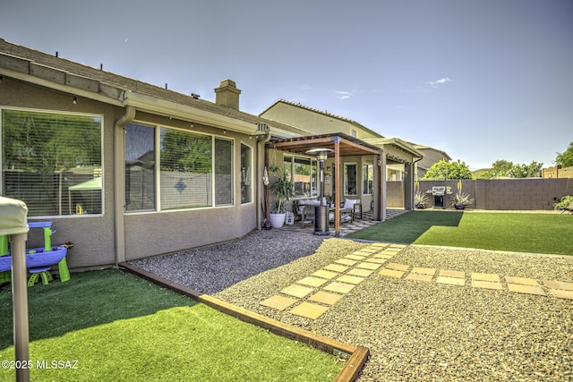 back of house with a lawn, a chimney, a patio, and a fenced backyard