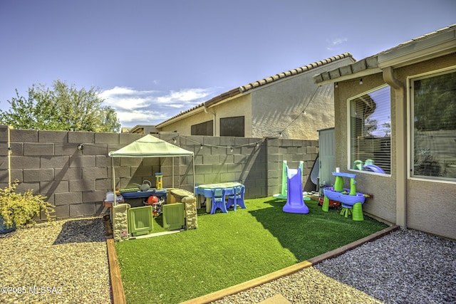 view of yard with fence and a playground