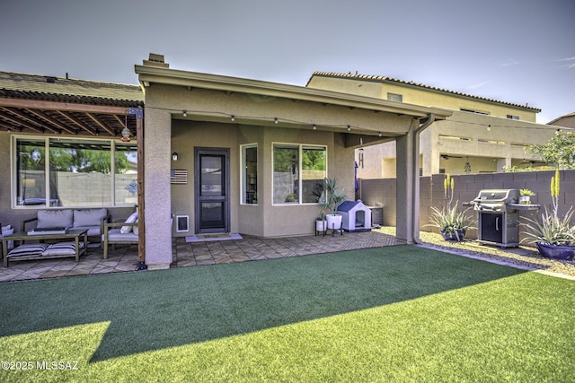 back of house featuring a patio area, an outdoor living space, a yard, stucco siding, and fence