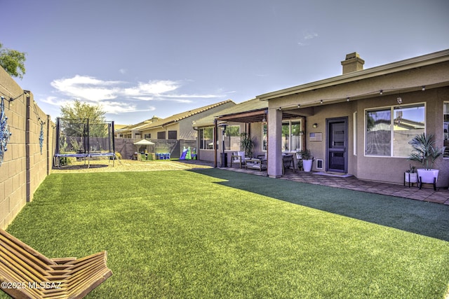 view of yard with a fenced backyard, a patio area, and a trampoline