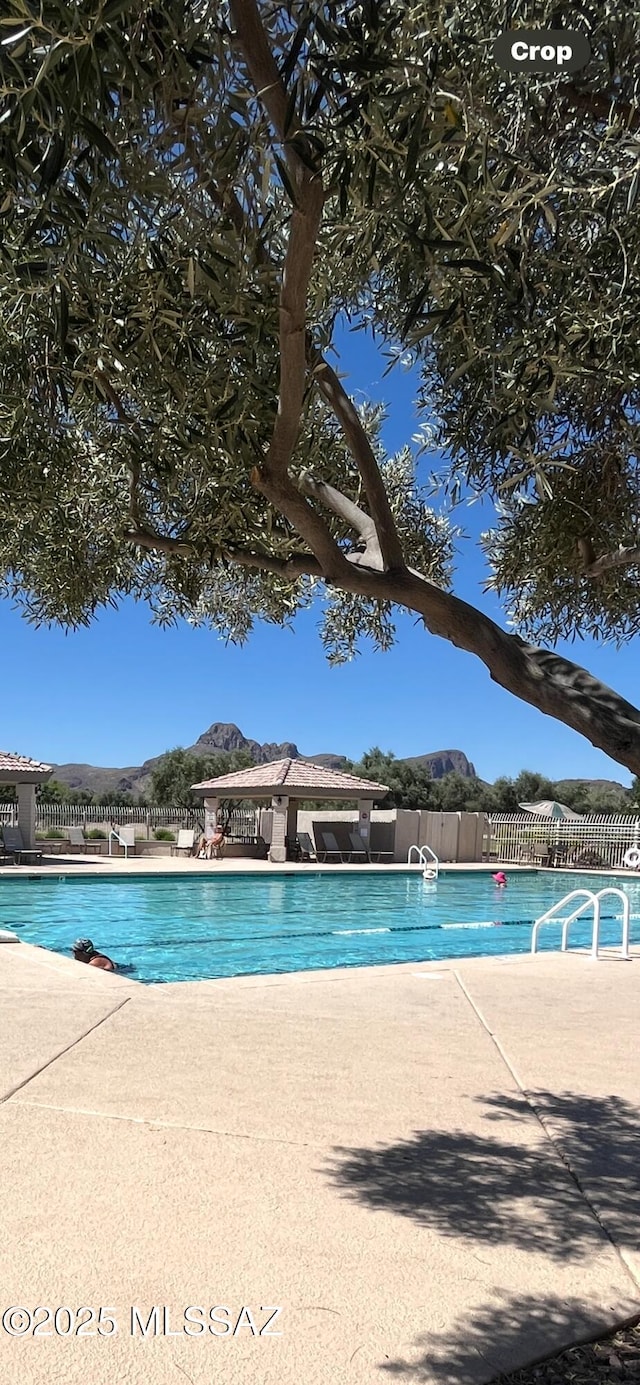 community pool with fence and a patio area