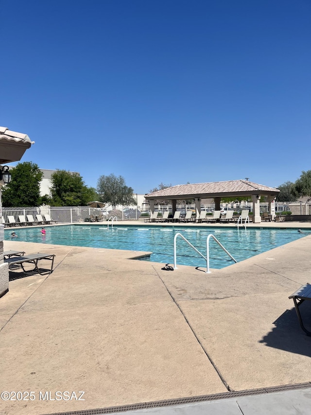 community pool with a patio, fence, and a gazebo