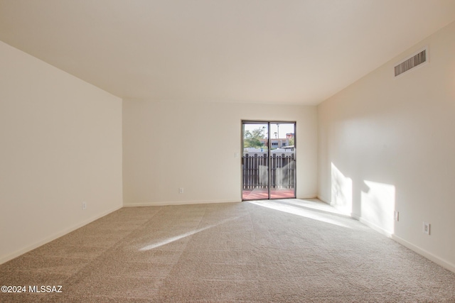 empty room with vaulted ceiling and carpet floors