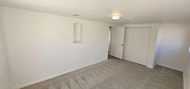 unfurnished bedroom with a closet and light carpet