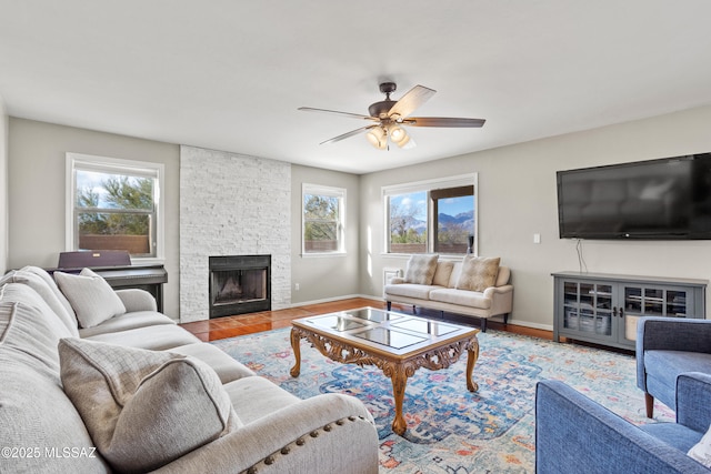 living room with ceiling fan, a fireplace, and hardwood / wood-style floors