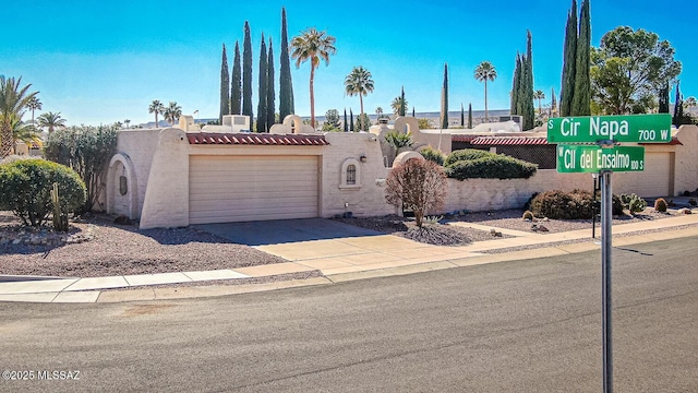 view of front of house featuring a garage, concrete driveway, and stucco siding