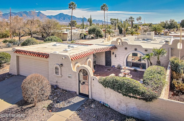 view of front of home featuring driveway, an attached garage, a mountain view, and stucco siding