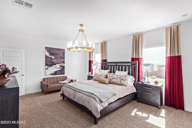 carpeted bedroom featuring an inviting chandelier, baseboards, and visible vents