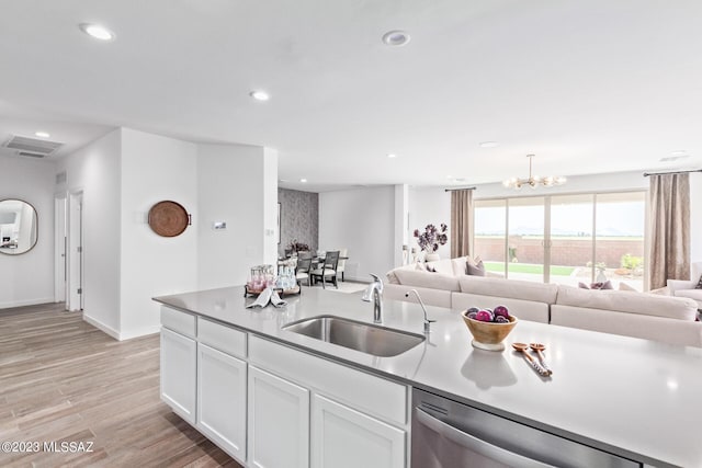 kitchen featuring recessed lighting, a sink, white cabinetry, open floor plan, and stainless steel dishwasher