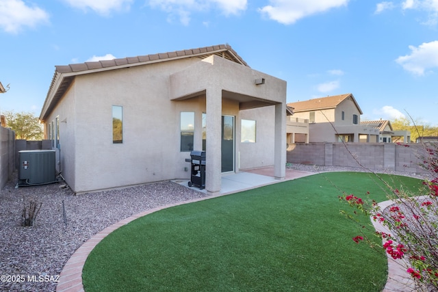 rear view of house featuring central AC, a yard, and a patio area