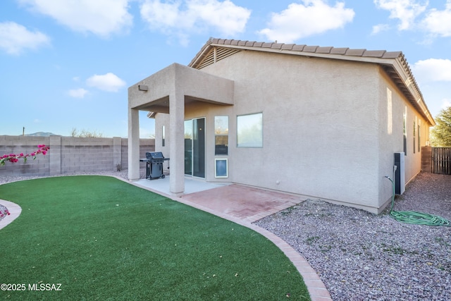 back of property featuring a yard and a patio