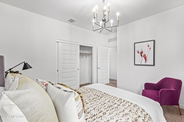 carpeted bedroom with visible vents, baseboards, a chandelier, and a closet