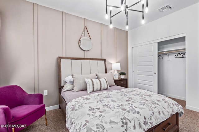 carpeted bedroom featuring a chandelier, baseboards, visible vents, and a closet