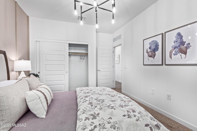 bedroom featuring visible vents, baseboards, a closet, dark colored carpet, and a chandelier