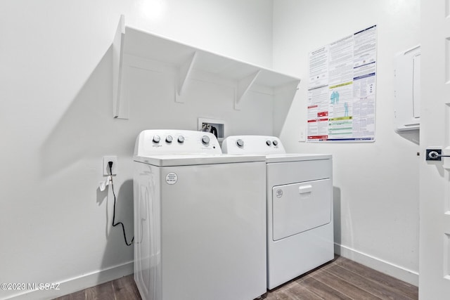 washroom with washer and dryer, laundry area, baseboards, and wood finished floors