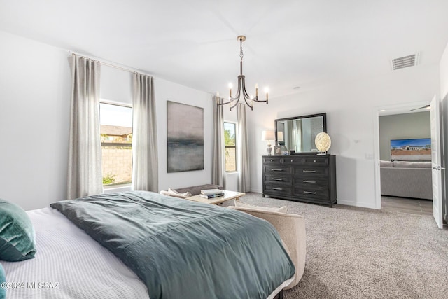 carpeted bedroom featuring an inviting chandelier and multiple windows