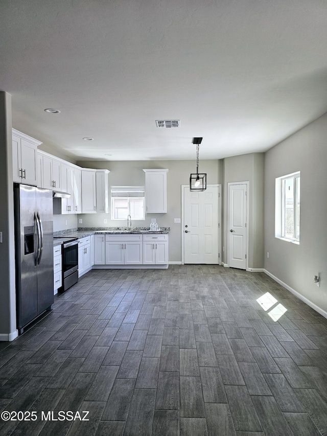 kitchen featuring visible vents, appliances with stainless steel finishes, white cabinets, a sink, and baseboards