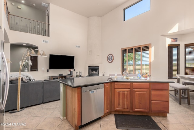 kitchen with light tile patterned flooring, stainless steel dishwasher, and sink