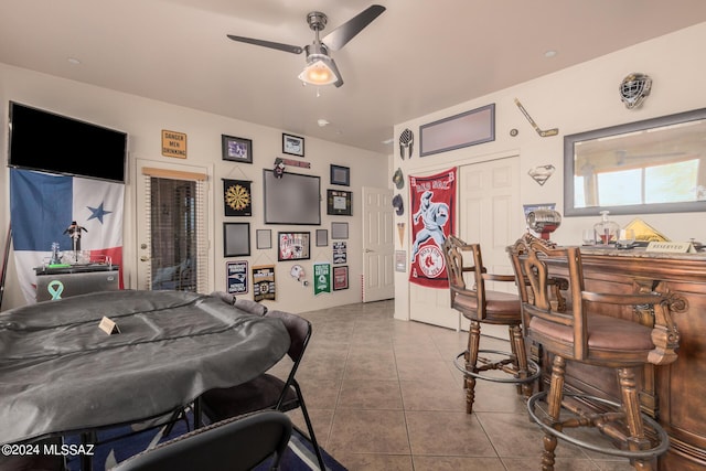 playroom with ceiling fan, bar, and tile patterned floors