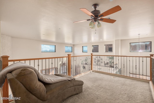 living area with ceiling fan and carpet