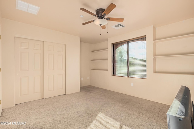 unfurnished bedroom featuring ceiling fan, light colored carpet, and a closet