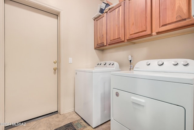 laundry area featuring cabinets, separate washer and dryer, and light tile patterned floors