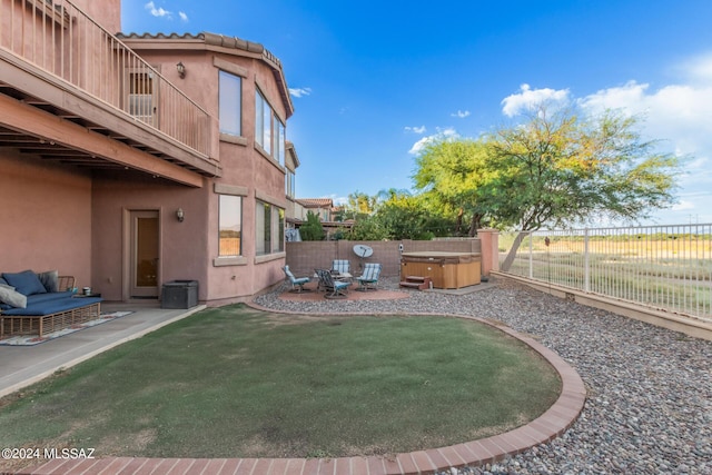 view of yard featuring a balcony, a hot tub, and a patio