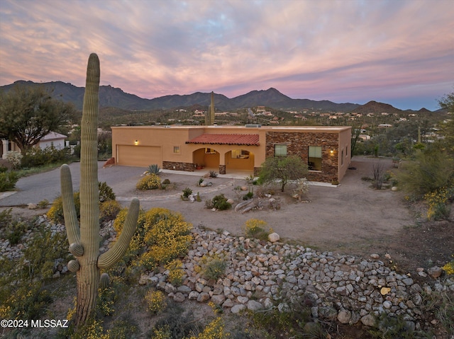 adobe home featuring a garage and a mountain view