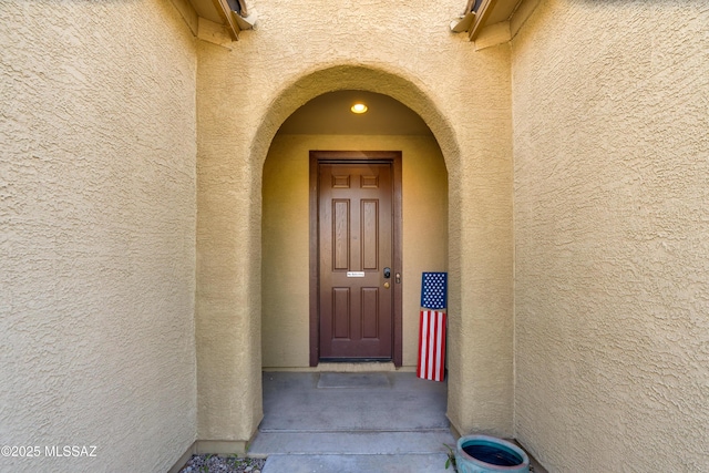 view of exterior entry with stucco siding