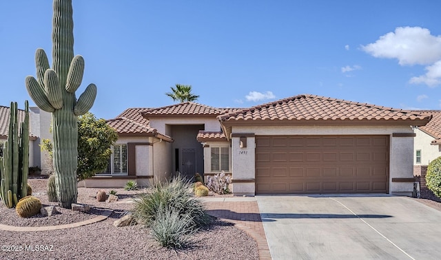 mediterranean / spanish-style home with a garage, a tile roof, concrete driveway, and stucco siding