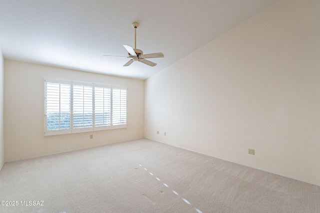 unfurnished room featuring light carpet, vaulted ceiling, and a ceiling fan