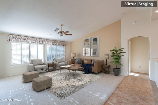 living room with arched walkways, light tile patterned floors, visible vents, ceiling fan, and high vaulted ceiling