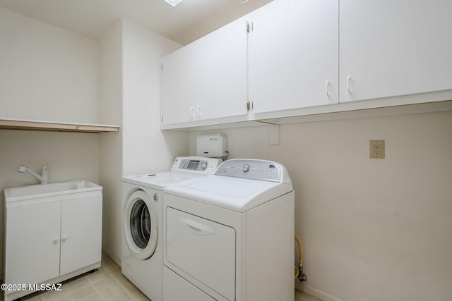 washroom featuring cabinet space, a sink, and washer and clothes dryer