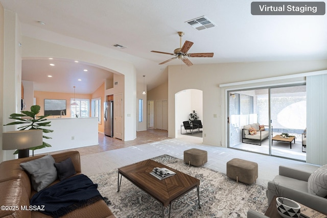 living area featuring arched walkways, visible vents, vaulted ceiling, and recessed lighting