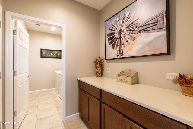 interior space featuring tile patterned flooring, visible vents, and baseboards