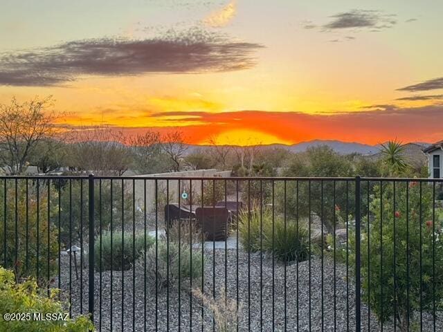 gate at dusk featuring a mountain view