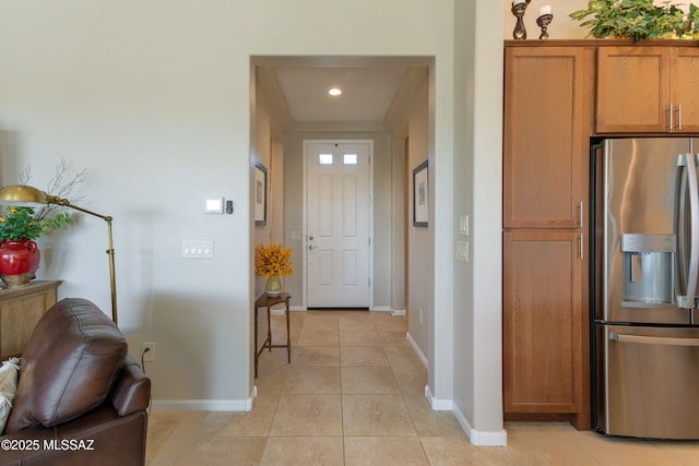 corridor featuring recessed lighting, baseboards, and light tile patterned floors