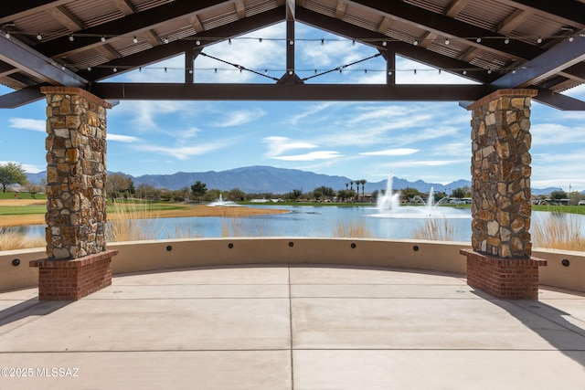 view of patio with a water and mountain view