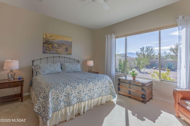 bedroom featuring ceiling fan, multiple windows, baseboards, and light colored carpet