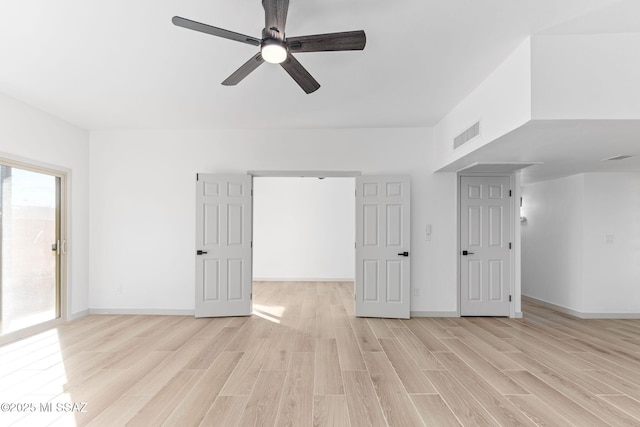 empty room featuring light wood-style floors, visible vents, baseboards, and a ceiling fan