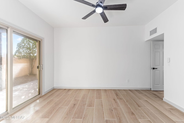 spare room featuring a ceiling fan, light wood-style flooring, visible vents, and baseboards