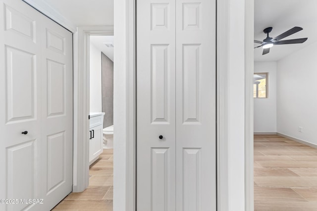 hallway featuring baseboards and wood tiled floor