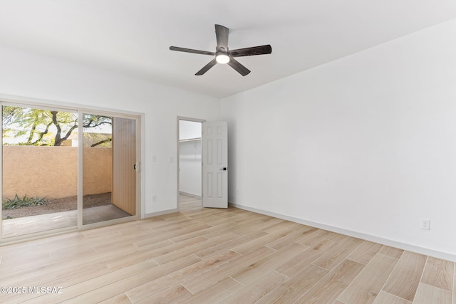 spare room with light wood-style floors, ceiling fan, and baseboards