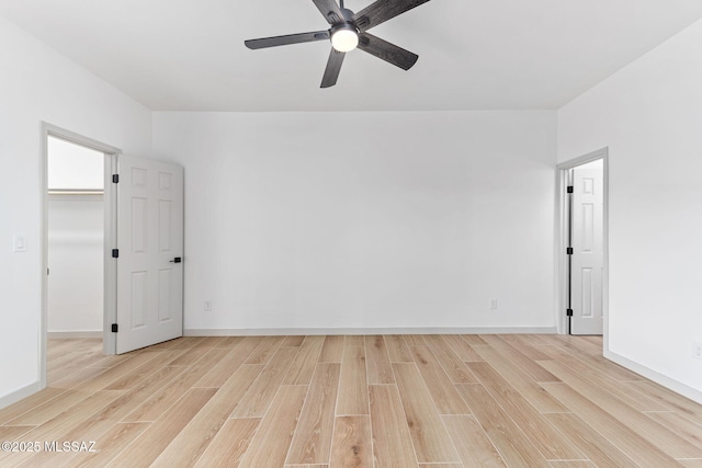 spare room with light wood-style flooring, baseboards, and ceiling fan