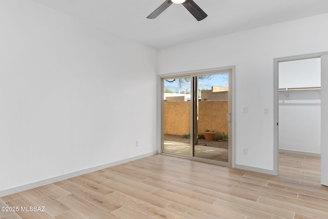 unfurnished bedroom featuring baseboards, ceiling fan, light wood-style floors, and access to exterior