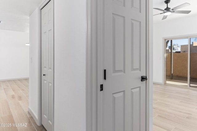 hallway with light wood finished floors and baseboards