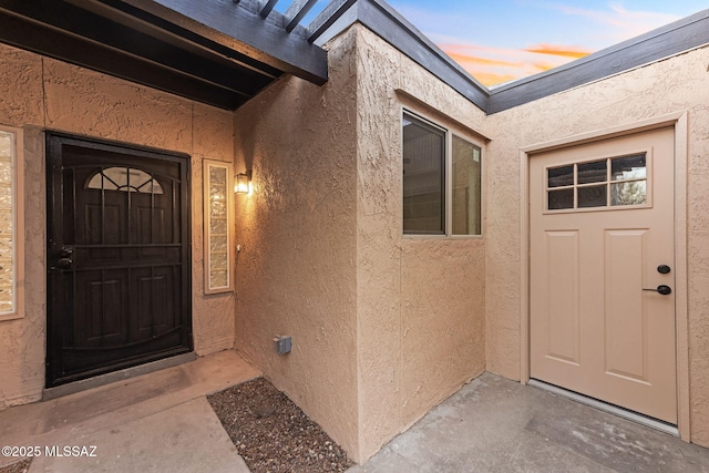 property entrance with stucco siding