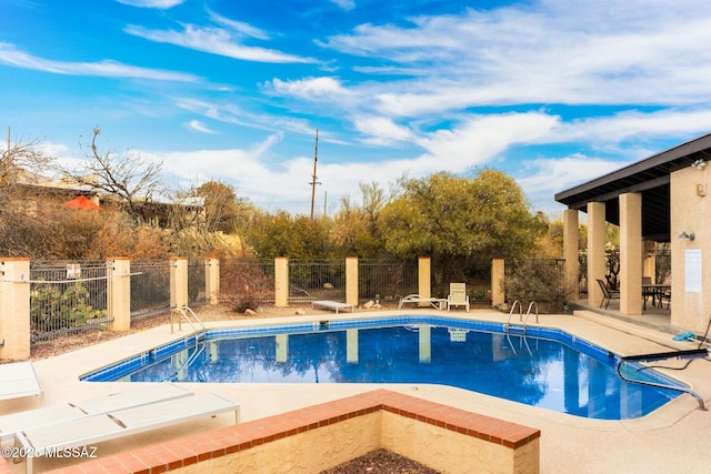 community pool featuring fence and a patio